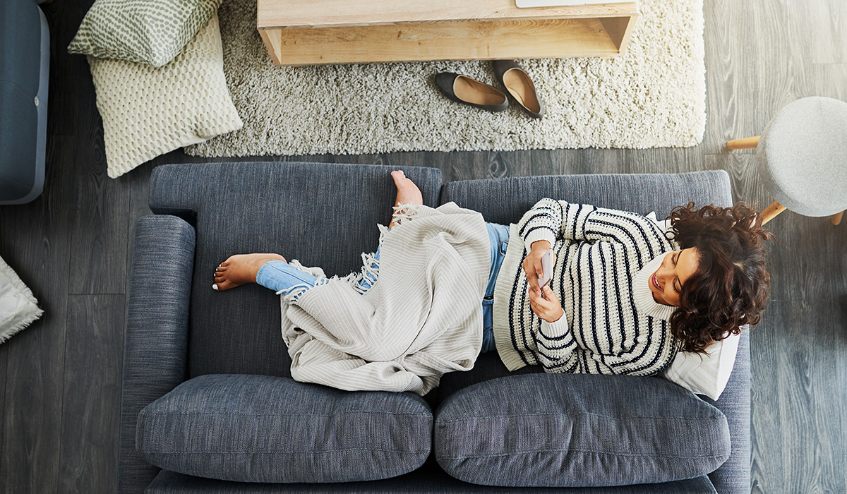 woman lying on the couch on her phone